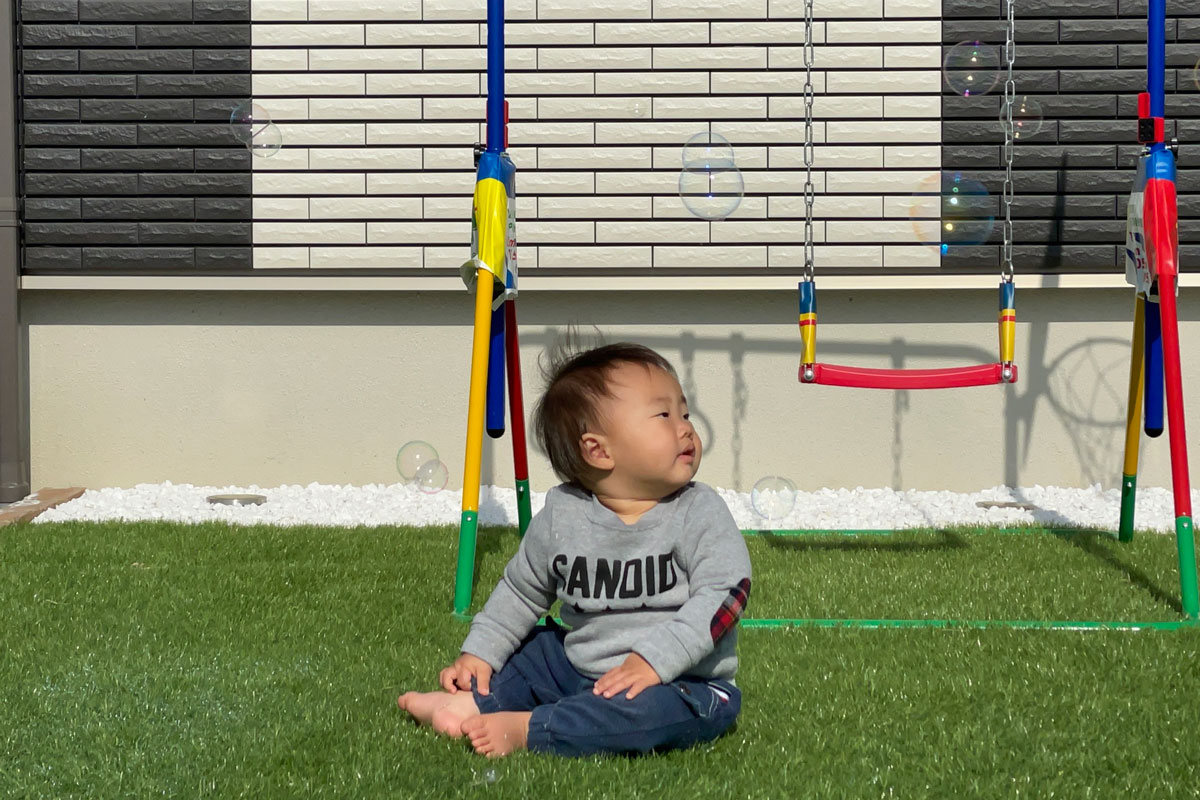 人工芝の上で遊ぶ赤ちゃんのイメージ写真